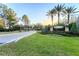 Welcoming entrance to Lakeshore Ranch with lush landscaping, mature palm trees and an American flag at 19837 Lonesome Pine Dr, Land O Lakes, FL 34638