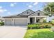 Beautiful home exterior with a three-car garage, manicured lawn, and inviting front porch, showcasing curb appeal at 19837 Lonesome Pine Dr, Land O Lakes, FL 34638