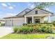 Attractive home featuring a well-manicured lawn, three-car garage, and classic architectural design at 19837 Lonesome Pine Dr, Land O Lakes, FL 34638