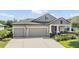 Charming home featuring a well-manicured lawn, elegant landscaping, and a spacious three-car garage at 19837 Lonesome Pine Dr, Land O Lakes, FL 34638