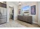 Bright hallway with a wooden console table, modern art and a window view with laundry room access at 19837 Lonesome Pine Dr, Land O Lakes, FL 34638