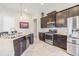Modern kitchen featuring dark wood cabinetry, stainless steel appliances, and granite countertops with recessed lighting at 19837 Lonesome Pine Dr, Land O Lakes, FL 34638