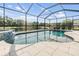 Screened-in pool with a waterfall feature and view of the pond at 19837 Lonesome Pine Dr, Land O Lakes, FL 34638