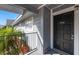 Charming condo balcony with gray wood siding, black door and black iron railing at 200 Country Club Dr # 906, Largo, FL 33771