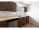 Cozy kitchen with wooden cabinets, stainless steel dishwasher, and a double stainless steel sink at 200 Country Club Dr # 906, Largo, FL 33771
