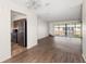 Bright living room with wood floors, adjacent kitchen, and sliding doors to a balcony at 200 Country Club Dr # 906, Largo, FL 33771