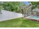 Exterior lawn view shows white fencing and screened-in pool area at 2010 Rutherford Dr, Dover, FL 33527