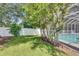 View of backyard area shows the screened pool and white privacy fence at 2010 Rutherford Dr, Dover, FL 33527