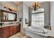 Bathroom featuring double vanities, a large garden tub, and tiled floors at 2010 Rutherford Dr, Dover, FL 33527