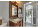 Vanity with granite countertop and decorative mirror in a bathroom leading to the sunroom at 2010 Rutherford Dr, Dover, FL 33527