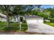 Charming home featuring a well-manicured lawn, mature landscaping, and a spacious three-car garage at 2010 Rutherford Dr, Dover, FL 33527