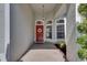 Inviting front entry with red door, decorative wreath, sidelight windows, and brick pavers at 2010 Rutherford Dr, Dover, FL 33527