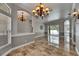 Open concept living room with travertine tile, designer lighting, neutral tones and patio doors at 2010 Rutherford Dr, Dover, FL 33527