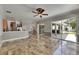 Spacious living room with tile flooring, kitchen bar, sliding glass doors, and access to backyard at 2010 Rutherford Dr, Dover, FL 33527