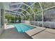 Backyard pool is screened and surrounded by trees and white fencing at 2010 Rutherford Dr, Dover, FL 33527