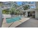 Screened-in pool area features a pristine pool, concrete deck, and access to the home's interior at 2010 Rutherford Dr, Dover, FL 33527