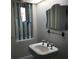 Cozy bathroom with a stylish pedestal sink, unique shuttered window, and decorative mirror at 2101 Sunset Point Rd # 2305, Clearwater, FL 33765