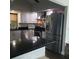 Kitchen showcases stainless steel appliances, white cabinets, microwave, black countertop, and tiled backsplash at 2101 Sunset Point Rd # 2305, Clearwater, FL 33765