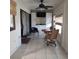 Sunroom with tiled floor, cabinets, television, roll-up shades, a round dining table and sliding glass door at 2101 Sunset Point Rd # 2305, Clearwater, FL 33765
