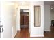 Hallway with wood floors, leading to folding doors and a glimpse of adjacent room at 2211 Harrison Dr, Holiday, FL 34691