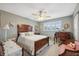 Cozy bedroom featuring wood furnishings, soft carpet, ceiling fan, and natural light from the shuttered windows at 2221 Swedish Dr # 55, Clearwater, FL 33763