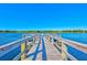 Inviting wooden dock extending into a tranquil lake with clear blue waters and beautiful natural surroundings at 2221 Swedish Dr # 55, Clearwater, FL 33763