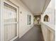 Condo 55's front door with storm door, small window and exterior walkway at 2221 Swedish Dr # 55, Clearwater, FL 33763
