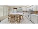 Spacious and bright kitchen with white cabinets, tile floors and center island with seating at 2221 Swedish Dr # 55, Clearwater, FL 33763