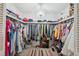 Organized walk-in closet with ample hanging space, shelving, crystal chandelier, and a decorative rug at 2221 Swedish Dr # 55, Clearwater, FL 33763