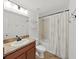 Bathroom features a shower with a white floral shower curtain and a wood vanity with granite countertop at 2405 Dakota Rock Dr, Ruskin, FL 33570
