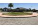 Community clubhouse entrance with brick-paved roundabout and lush landscaping at 2405 Dakota Rock Dr, Ruskin, FL 33570
