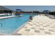 Resort-style community pool with sun loungers, sunshades, and lake views at 2405 Dakota Rock Dr, Ruskin, FL 33570
