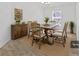 Staged dining room featuring modern table, six chairs, and accent cabinet with a large window at 2405 Dakota Rock Dr, Ruskin, FL 33570