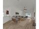 Staged living room featuring vaulted ceilings, modern fan, neutral furniture and light wood floors at 2405 Dakota Rock Dr, Ruskin, FL 33570