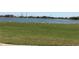Scenic pond view with lush green lawn and distant houses, offering a peaceful atmosphere at 2405 Dakota Rock Dr, Ruskin, FL 33570