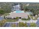 Aerial view showcasing the pool, shuffleboard, clubhouse, and beautiful landscaping in a lakefront community at 2567 Oakleaf Ln # 41B, Clearwater, FL 33763