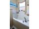 Bathroom soaking tub with tile surround, window, and decorative decor at 2604 Clareside Dr, Valrico, FL 33596