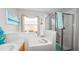 Bathroom with bathtub, shower, window, and coastal decor at 2604 Clareside Dr, Valrico, FL 33596