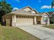 Inviting home showcasing a two-car garage with brick accents and driveway at 2604 Clareside Dr, Valrico, FL 33596