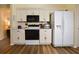 Bright kitchen featuring white cabinetry, modern appliances, and wood flooring at 2604 Clareside Dr, Valrico, FL 33596