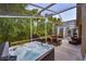 Wide angle view of a screened-in patio featuring outdoor dining, a grill, and a hot tub at 2604 Clareside Dr, Valrico, FL 33596