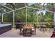 Screened-in patio featuring outdoor dining, a grill, hot tub, and views of the lush backyard at 2604 Clareside Dr, Valrico, FL 33596