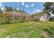 Back yard featuring colorful flowers, green grass, and a screened lanai at 3001 Folklore Dr, Valrico, FL 33596