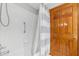 A cozy bathroom featuring a shower with white tile, a shower curtain, and wooden door at 3001 Folklore Dr, Valrico, FL 33596
