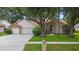 Charming single-Gathering home with well-manicured lawn, mature trees, and a two-car garage at 3001 Folklore Dr, Valrico, FL 33596