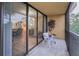 Balcony with a chair, side table, and a view of lush green trees and a partially visible interior at 3062 Eastland Blvd # 402, Clearwater, FL 33761