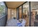 A cozy balcony with a chair, a door to the hallway and sliding glass doors leading to the living room at 3062 Eastland Blvd # 402, Clearwater, FL 33761
