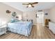 Comfortable bedroom with wood-look floors and beach-themed decor and a hallway that leads to the bathroom at 3062 Eastland Blvd # 402, Clearwater, FL 33761