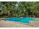 Large community pool surrounded by lush greenery and mature trees at 3062 Eastland Blvd # 402, Clearwater, FL 33761