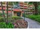 Building entrance featuring well-kept landscaping with colorful foliage at 3062 Eastland Blvd # 402, Clearwater, FL 33761